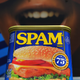 A can of Spam meat is pictured on a giant sign with an open mouth behind it.